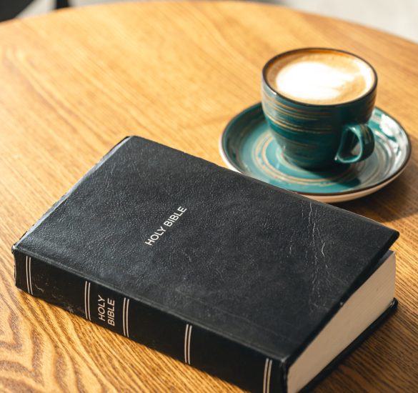 A cup of coffee and a Bible on a wooden table, close-up, the concept of Christianity, faith in God.